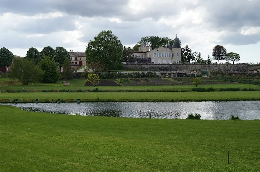 2013-4-28に酒井 浩（プラチナワイン（有限会社デリバリー・ワイン）代表）がボルドー、メドック地区、ポイヤック村、シャトー・ラフィット・ロートシルトで撮影したシャトー・ラフィットの城と、広大な敷地に鏡のように広がる池を有する優雅な風景