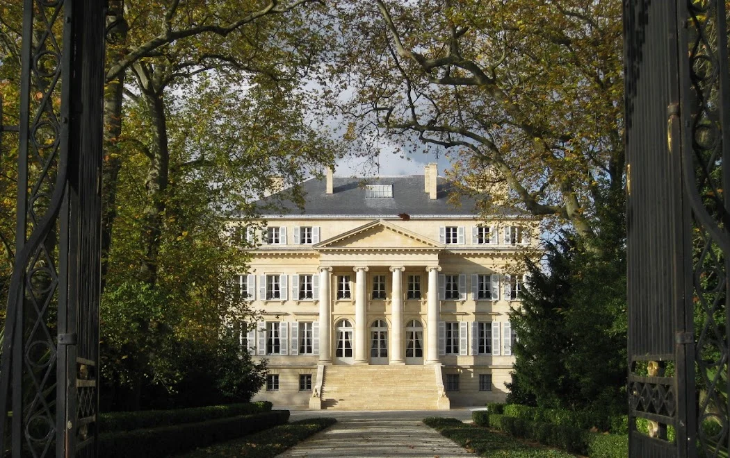 2008-11-6に酒井 浩（プラチナワイン（有限会社デリバリー・ワイン）代表）がボルドー、メドック地区、マルゴー村、シャトー・マルゴーで撮影した歴史あるアイアンゲートを額縁に見立てて撮影した、シャトー・マルゴー本館。4本のイオニア式柱が支える三角形のペディメント（破風）は、パッラーディオ様式の極致であり