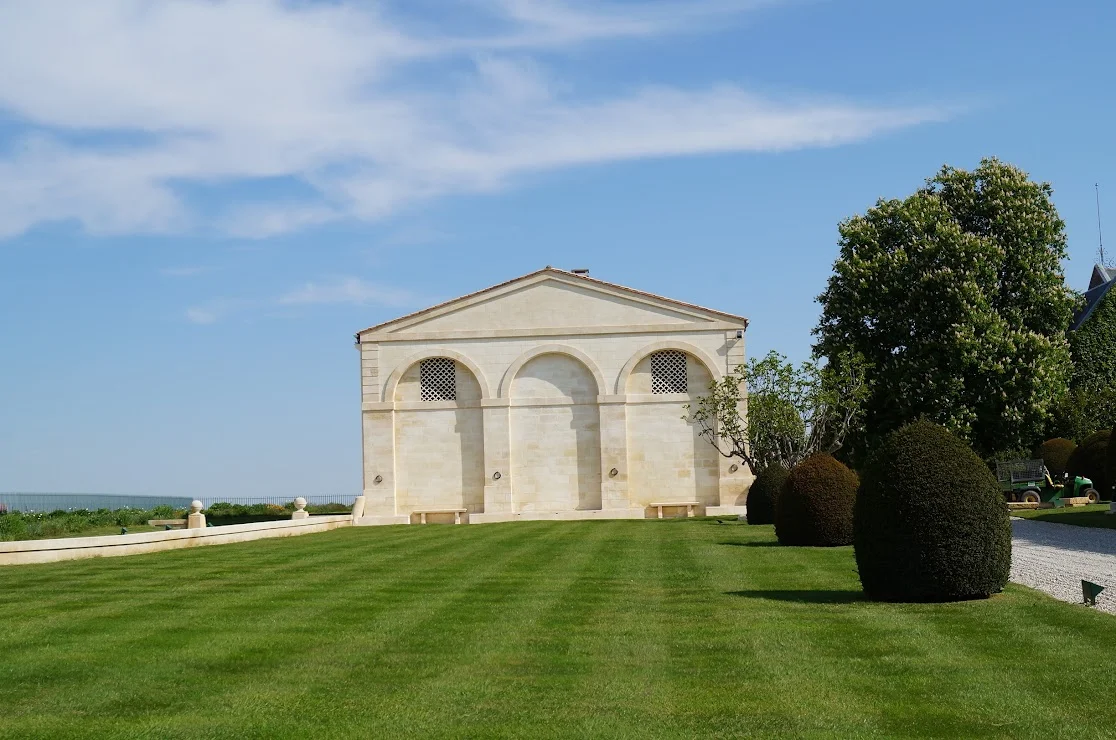 2013-04-29に酒井 浩（プラチナワイン（有限会社デリバリー・ワイン）代表）がシャトー・ムートン・ロートシルト / Pauillac, Médoc, Bordeaux, Franceで撮影した三連アーチと古典的ペディメントを備えた新古典主義パヴィリオン「Le Petit Mouton」。手入れの行き届いた芝生の前庭と球形トピアリーが美しく、ジロンド川