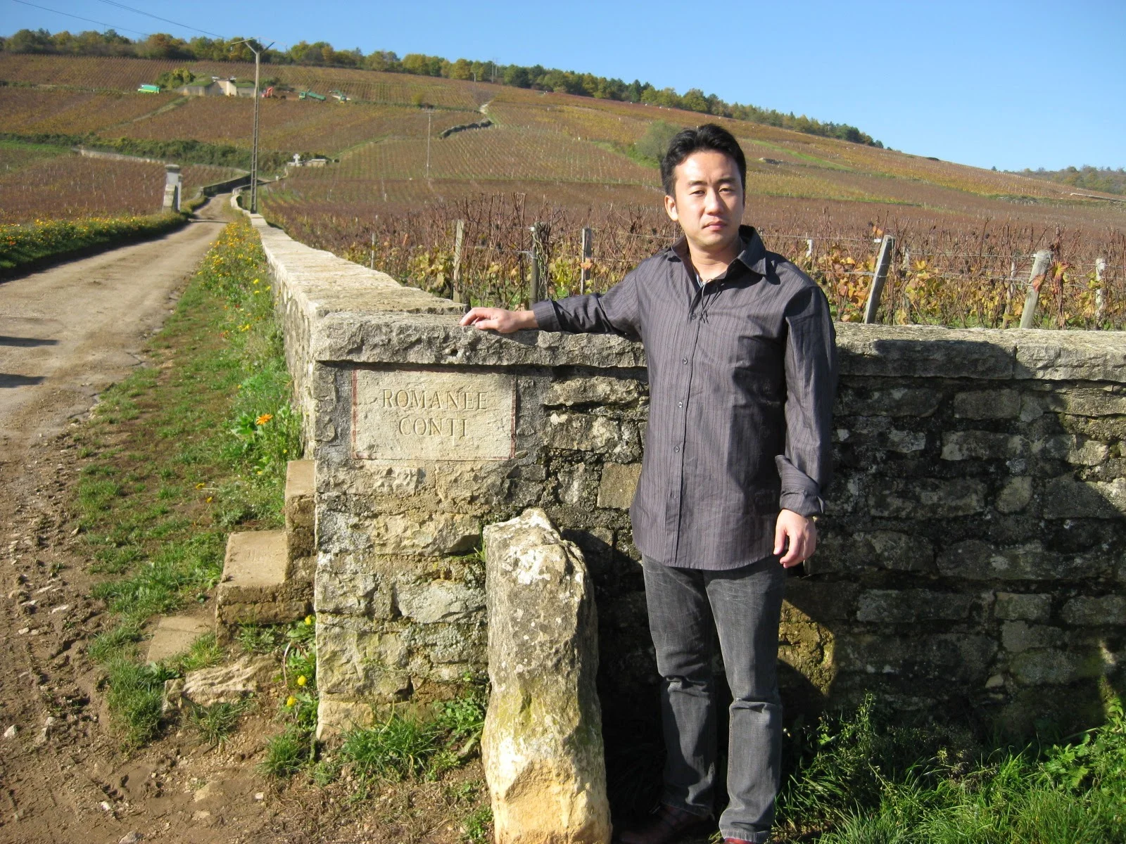 ROMANÉE CONTI石碑の前で記念撮影、背景に伝説的な1.8haの畑
